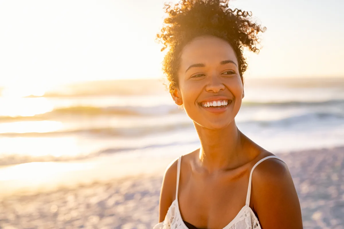 A smiling woman at the beach in golden evening light