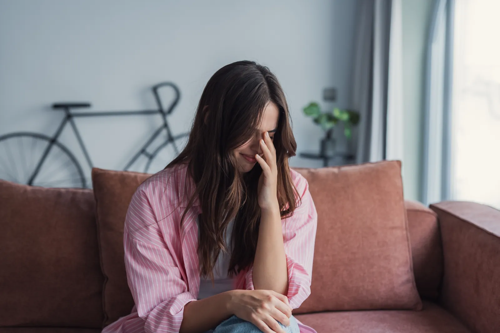 A distressed woman sitting on a couch