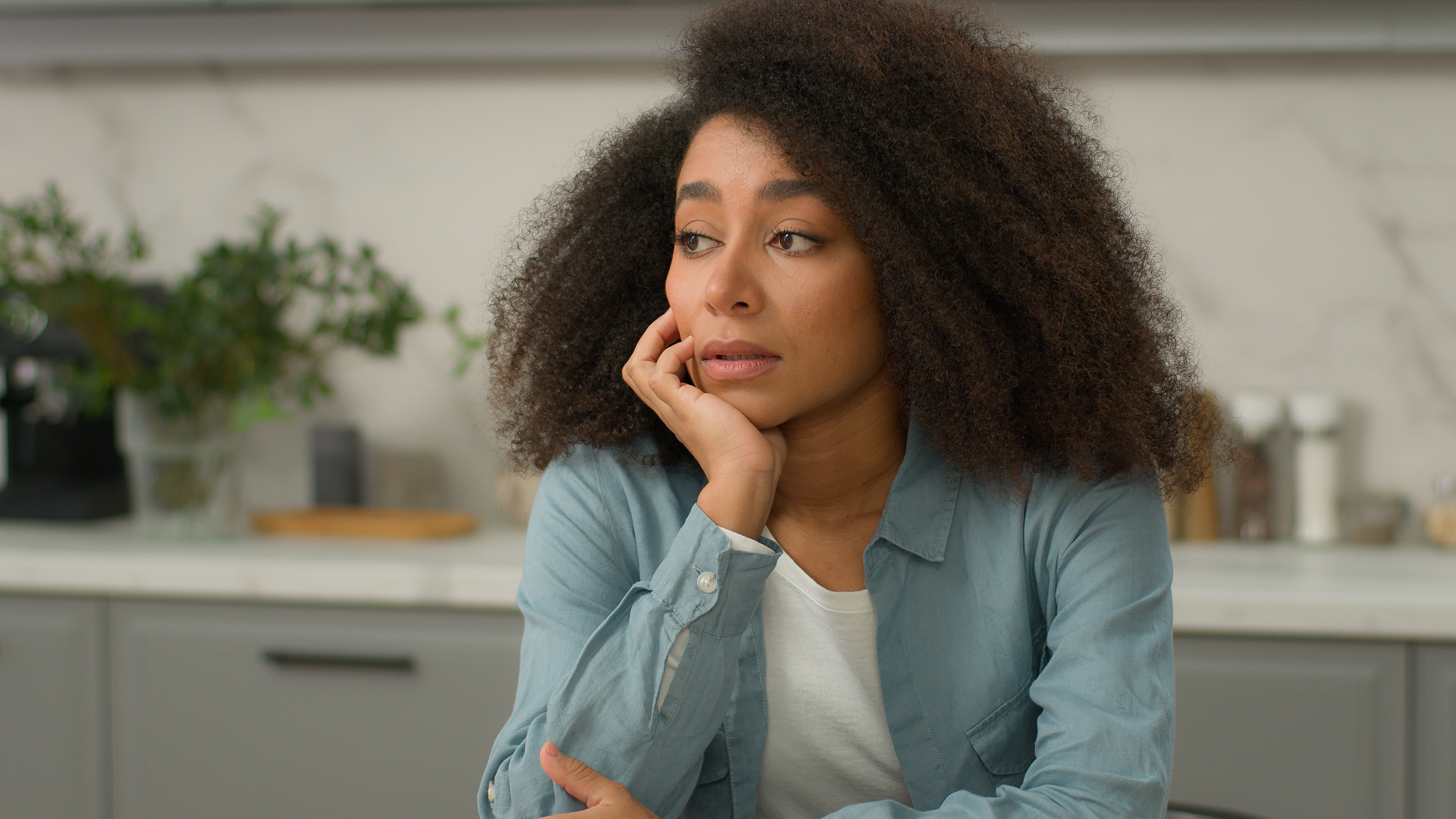 A contemplative woman with curly hair at home; personality disorder treatment for women in Huntington Beach.