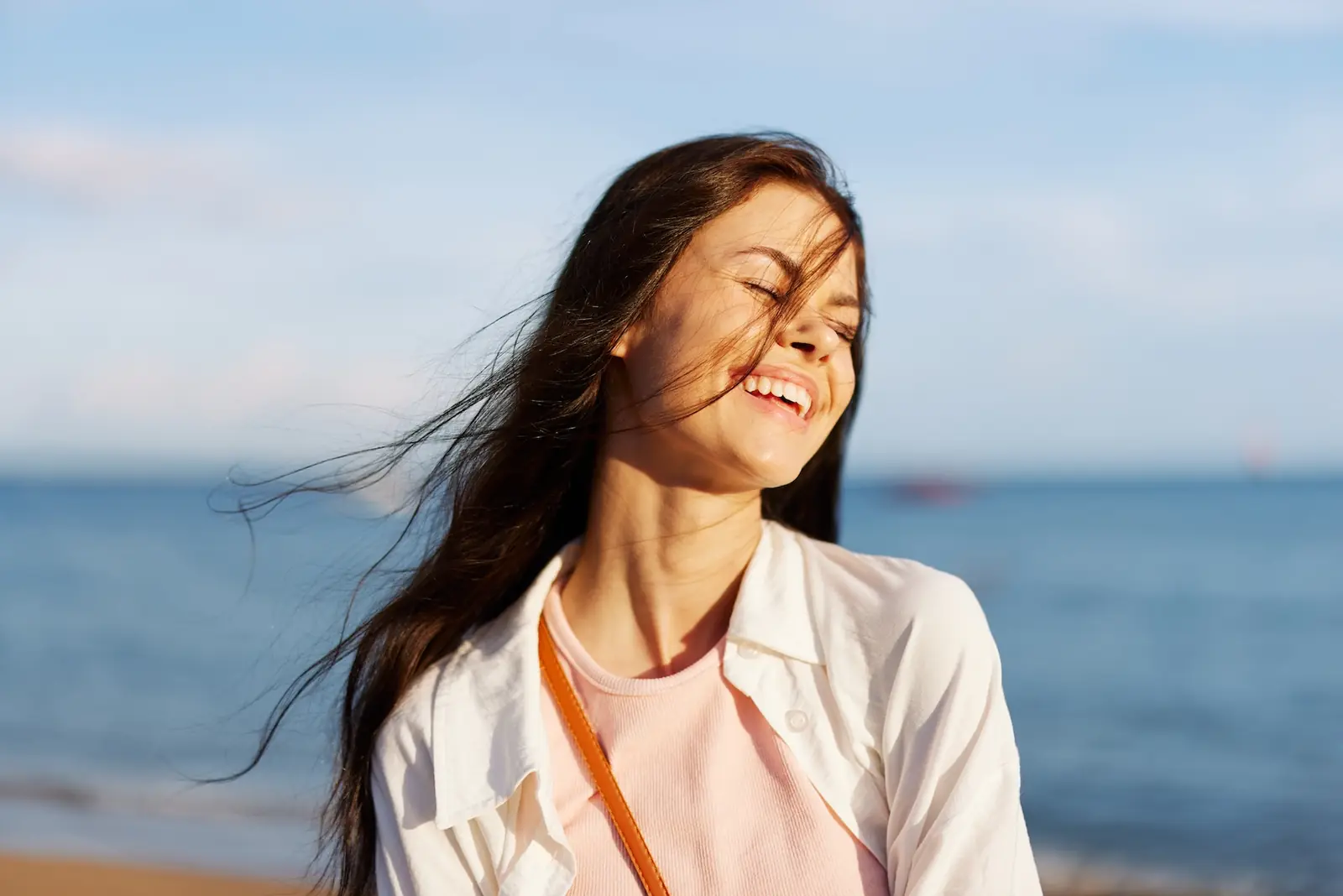 A woman with eyes closed in warm sunlight — a moment of calm in recovery