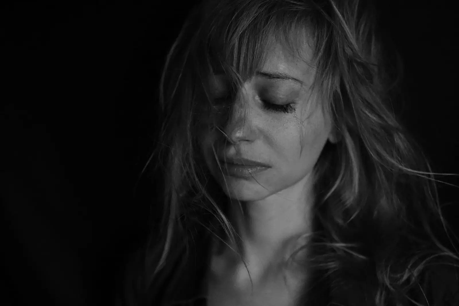 A pensive black-and-white portrait of a woman, conveying depression and inner quiet