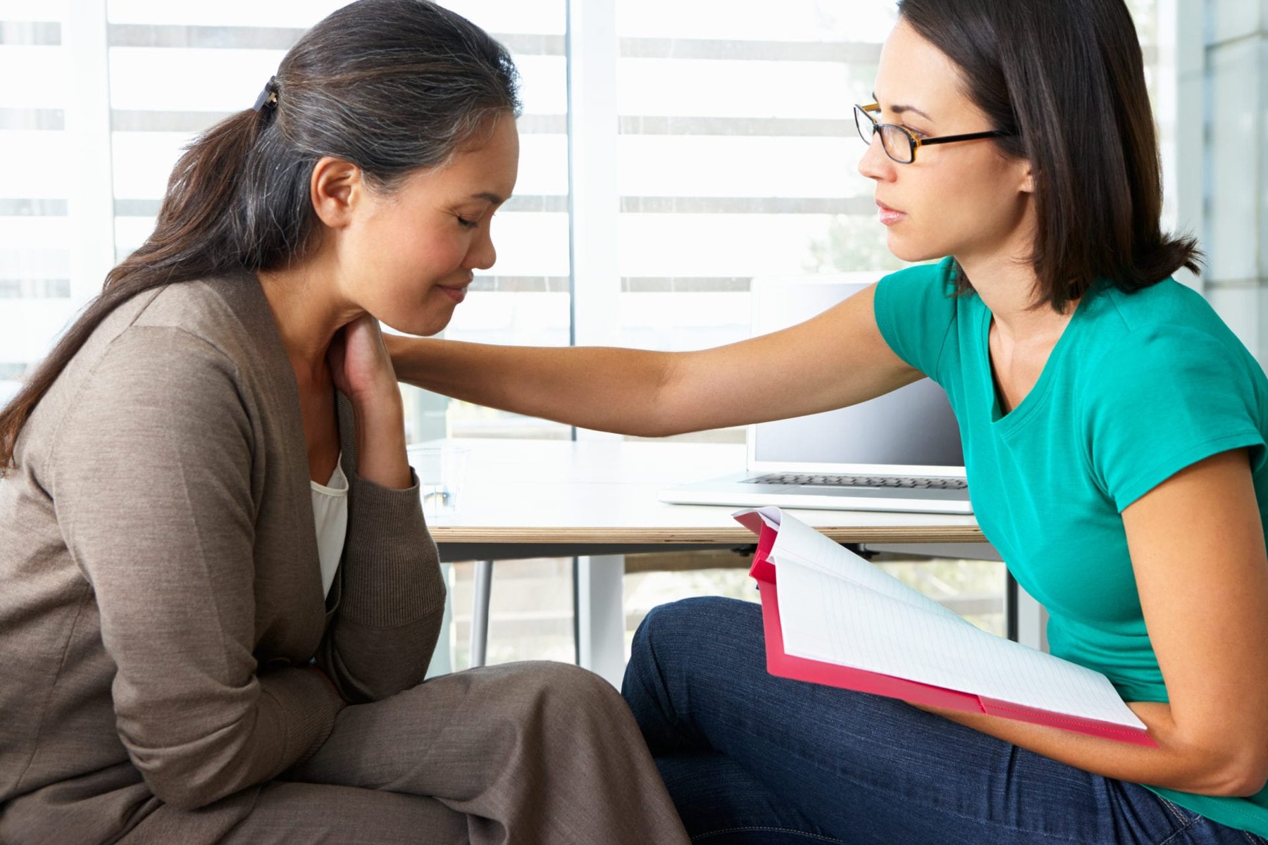 A counselor offering support to a woman during a conversation