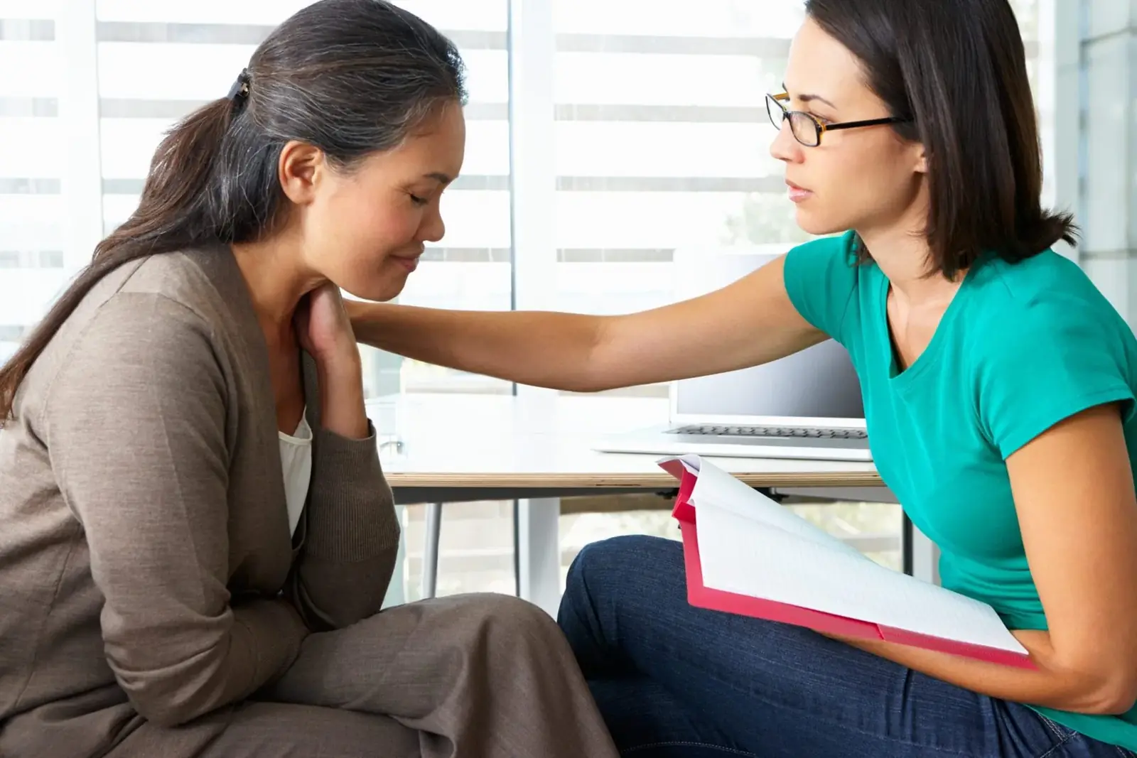 Counselor comforting a woman in a therapy session