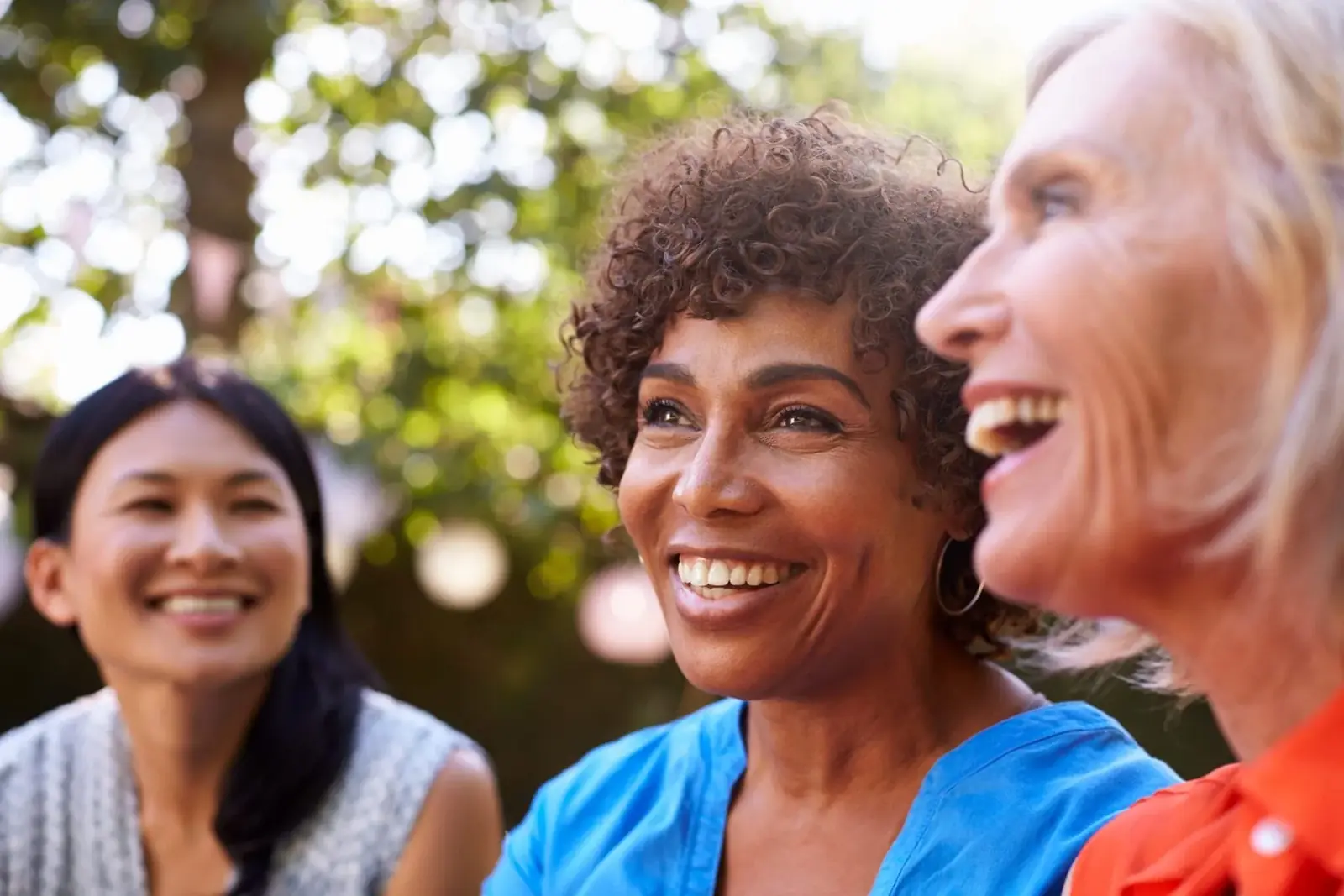 A group of diverse women laughing and connecting outdoors