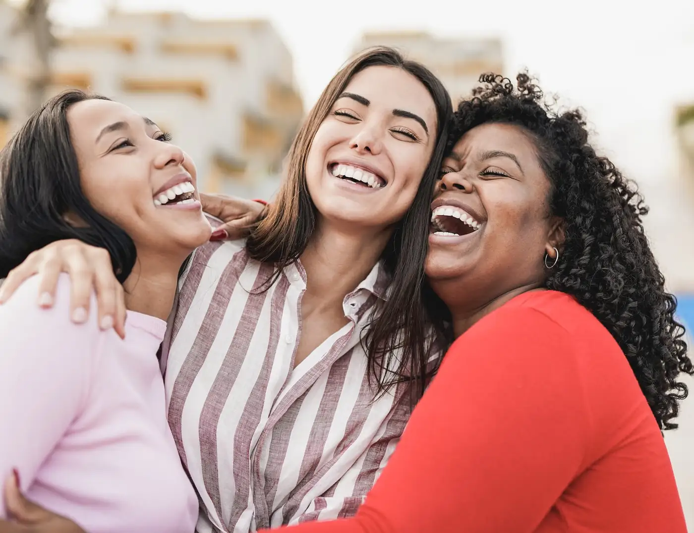Two women laughing and embracing — connection is central to women-only recovery