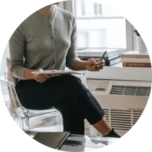 A woman writing notes while speaking with a counselor