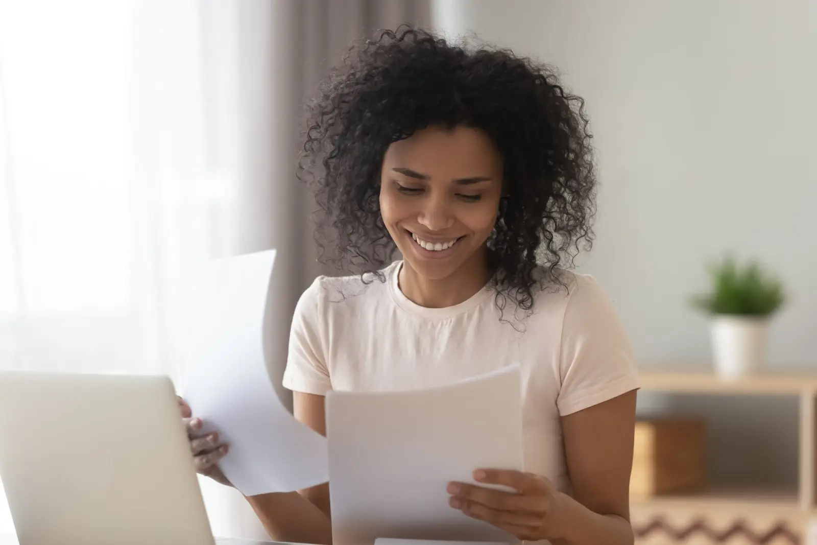 A woman reviewing insurance documents at her laptop