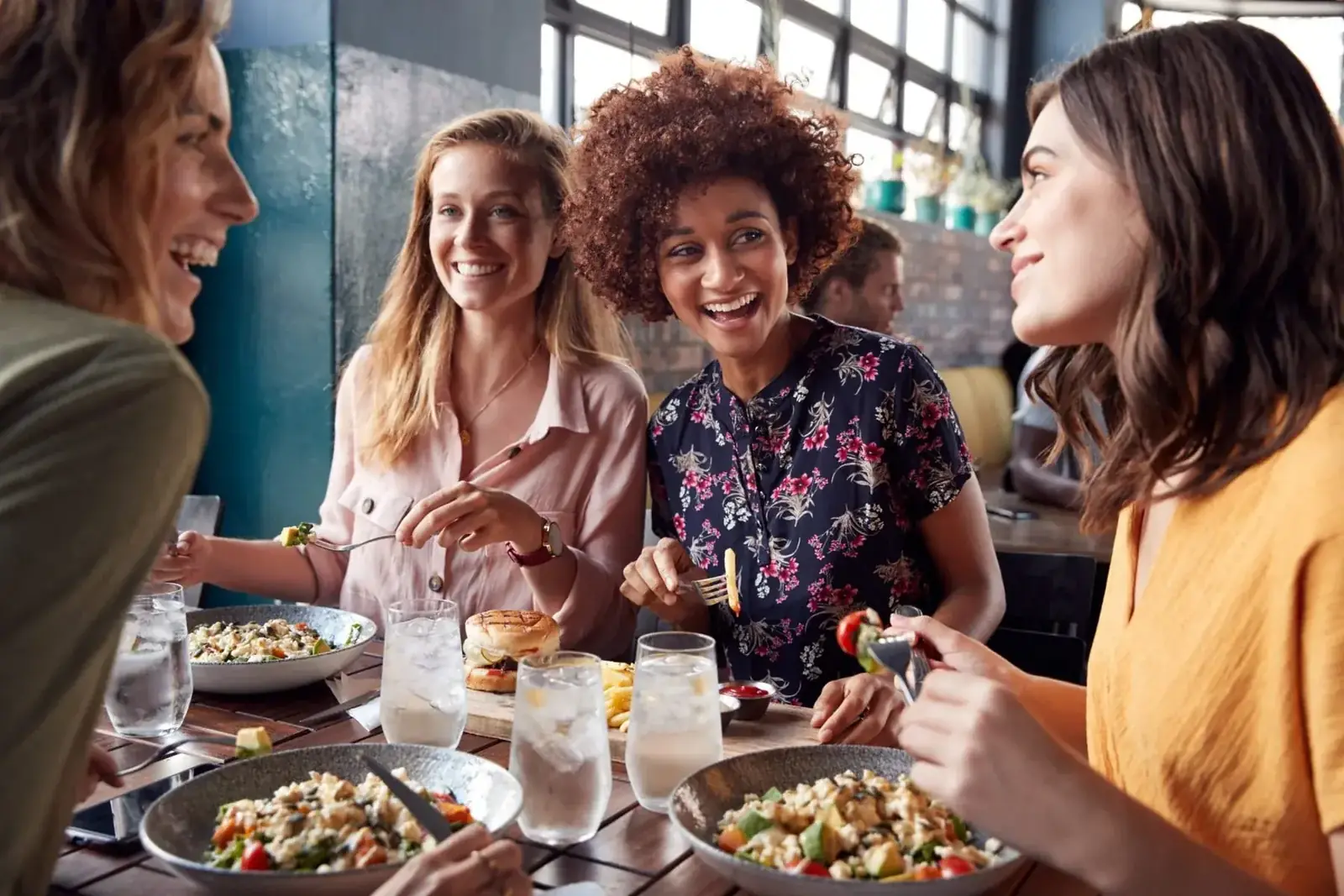 Women sharing a relaxed, nourishing meal together in a warm, supportive setting