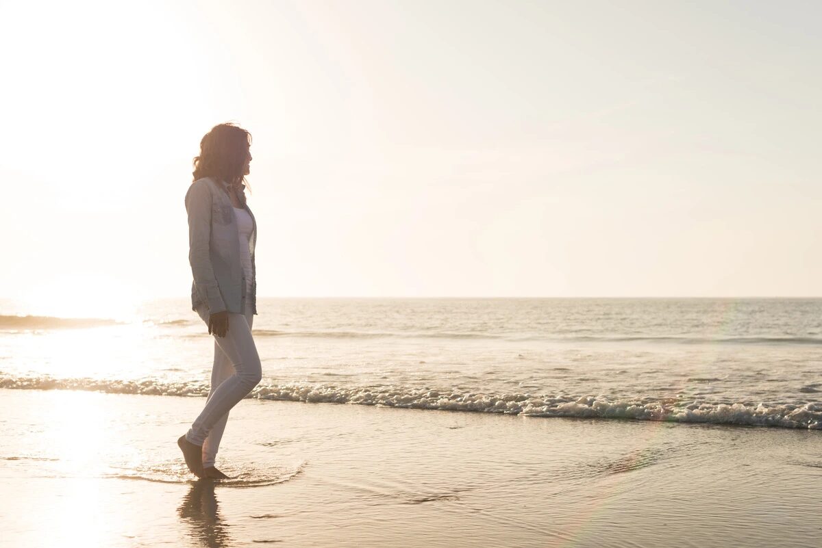 Anchored Tides Recovery - female walking on the beach