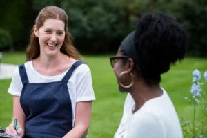 Woman and female therapist talking in a garden.
