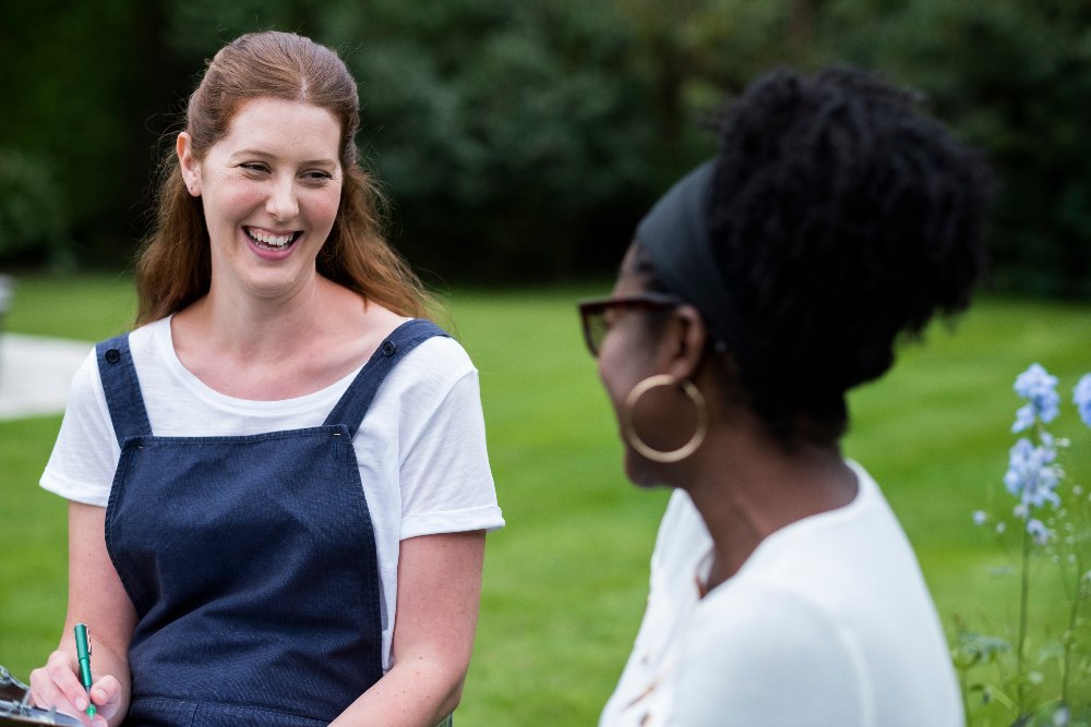 Woman and female therapist talking in a garden.
