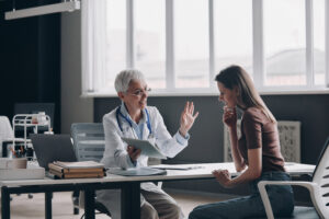 A woman speaking with a doctor in an office and asking how to get into rehab.